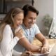 happy couple researching online to sell structured settlement payments