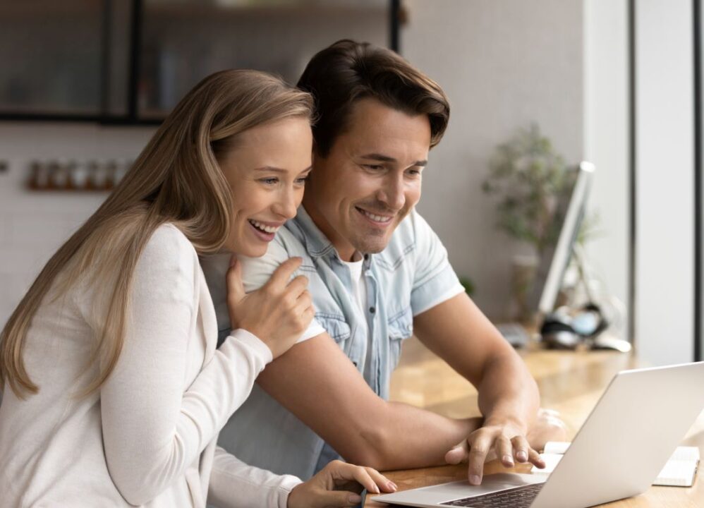 happy couple researching online to sell structured settlement payments