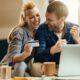 young couple on laptop researching ways to build their credit