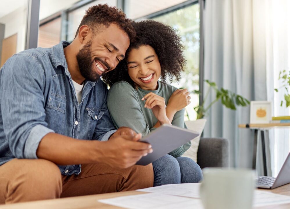 Happy couple reviewing documents and planning finances together, exploring options for selling a structured settlement.