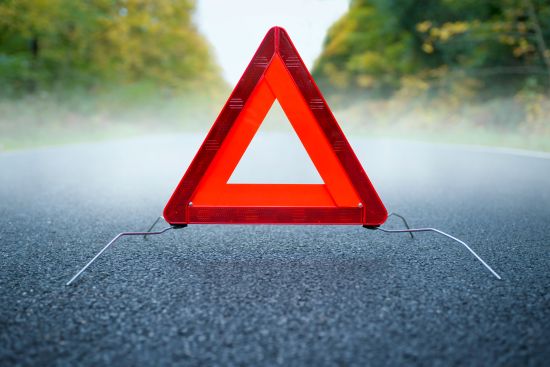 warning triangle placed on a road, symbolizing Gloria Estefan bus accident.