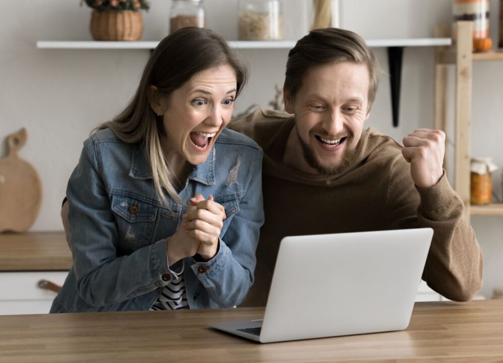 Excited couple celebrating their financial progress with a structured settlement buyout.