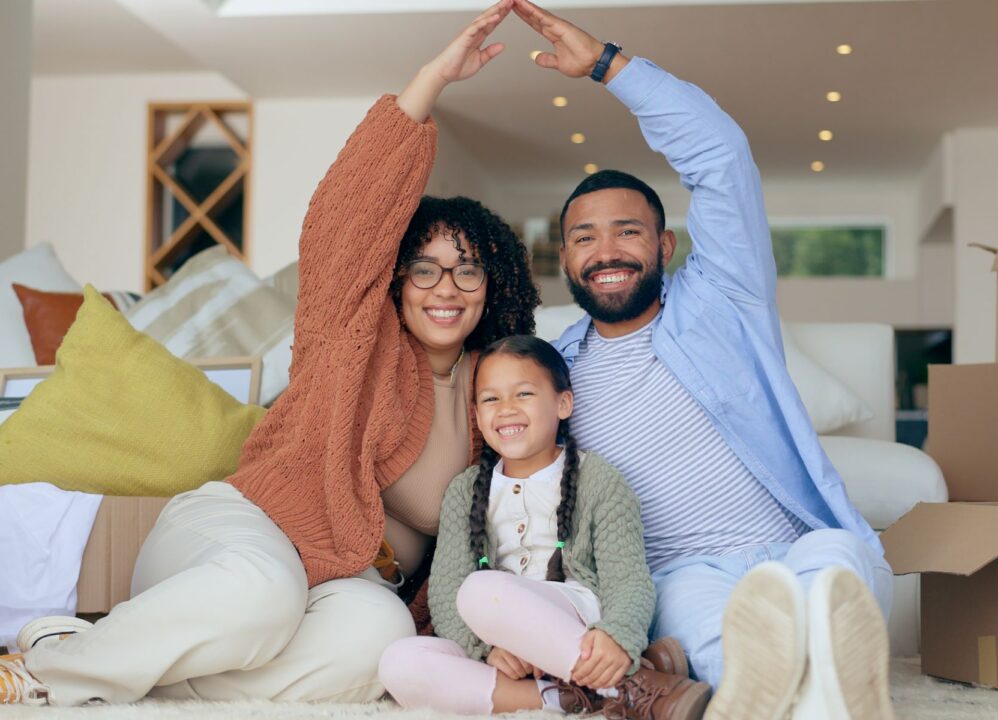 Family celebrating their new home among moving boxes.